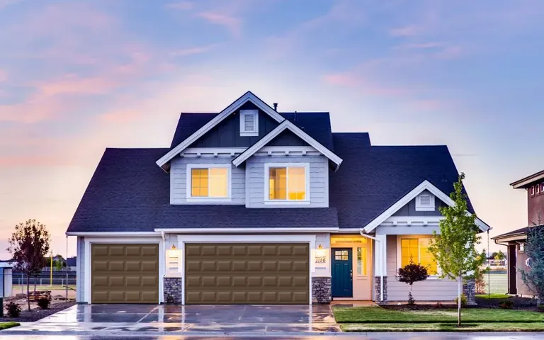 Two-story home with plain brown raised-panel garage doors and no windows