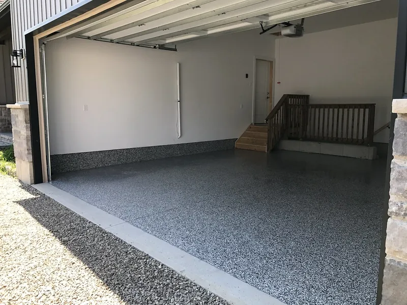 Two-car garage with a gray flake floor coating, seen through the open door